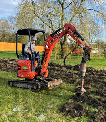 A digger preparing the ground for planting trees